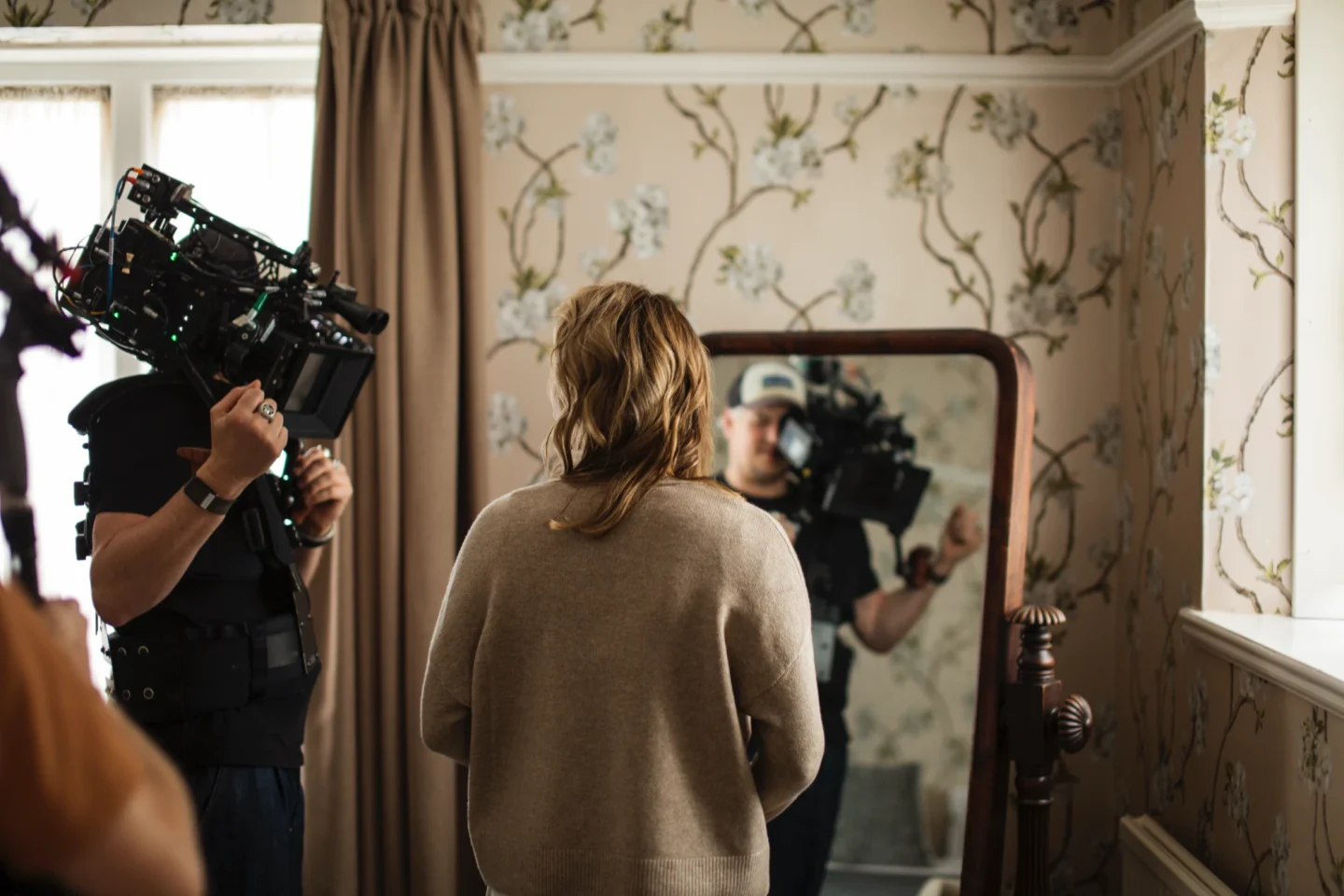 Actor looking into mirror being filmed